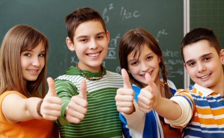 Portrait of happy teens showing thumbs up
